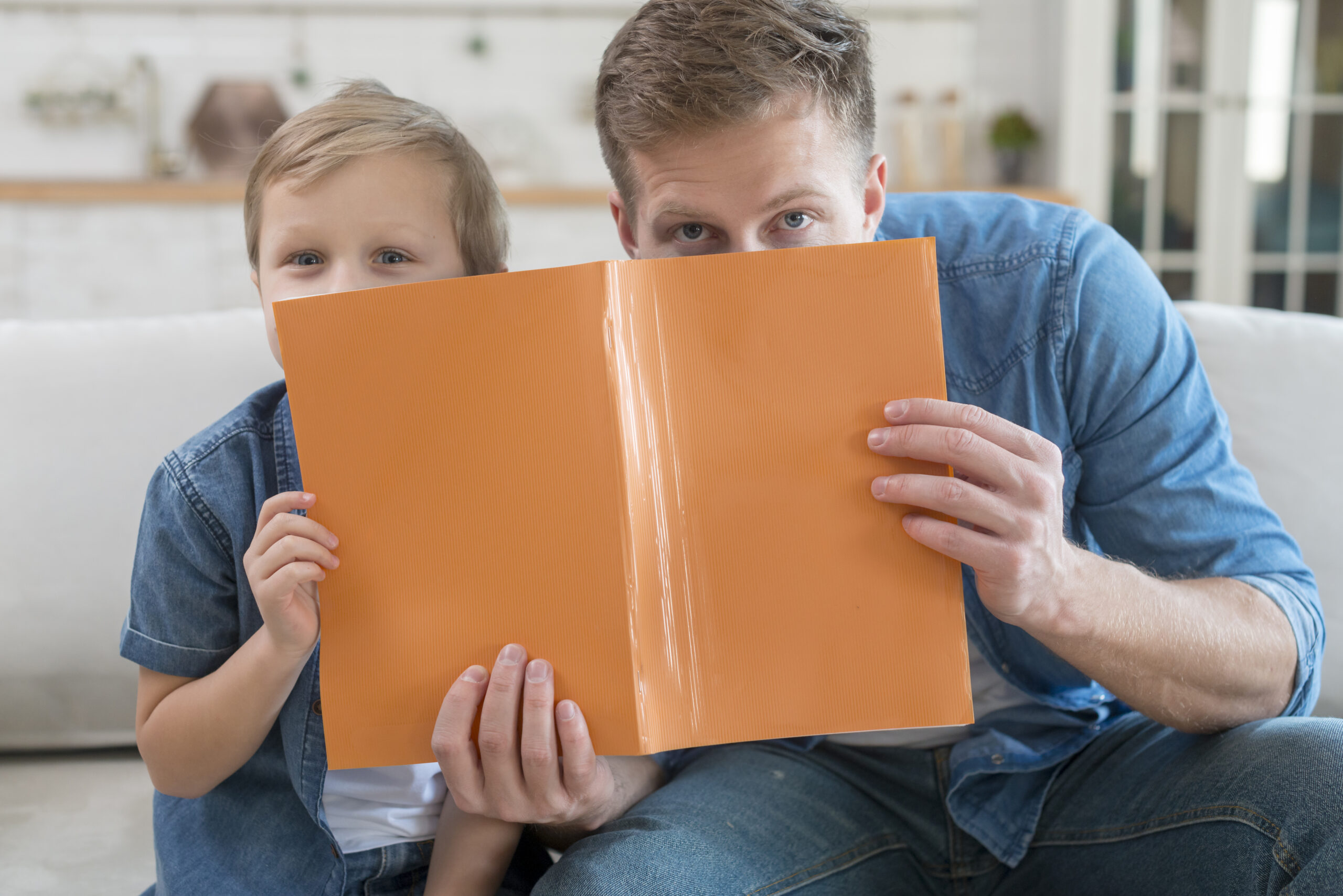 padre-e-hijo-escondidos-detras-de-una-libreta